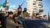 Anti-government fighters brandish their guns as they ride a vehicle in Syria's northern city of Aleppo on November 30.