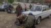 Tetyana, 75, an evacuee from the town of Vovchansk, stands next to the car in which she and her husband fled as they arrive at an evacuation point in the Kharkiv region on May 12.