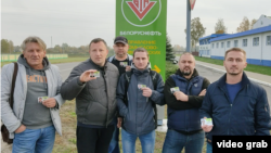 Workers from the Belorusneft petroleum company who were fired after supporting the national strike show their ID cards.