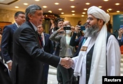 Russia's presidential envoy to Afghanistan, Zamir Kabulov (left), shakes hands with Mawlawi Shahabuddin Dilawar, a representative of the Taliban delegation, before the beginning of international talks on Afghanistan in Moscow in October.