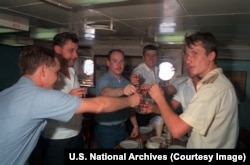 Russian and U.S. sailors prepare to down shots aboard a Russian guided missile destroyer.