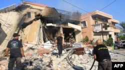 Rescuers inspect the debris at the site of an overnight Israeli strike on a pharmacy in the southern Lebanese village of Akbiyeh on September 24.