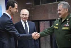 Putin (center), Syrian President Bashar al-Assad (left) and Russian Defense Minister Sergei Shoigu visit the headquarters of Russian forces in Damascus on January 7.