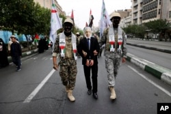 Iranian Basij paramilitary force members, dressed in the style of Palestinian and Lebanese militants, portray the detention of Israeli Prime Minister Benjamin Netanyahu during a pro-Palestinian rally in Tehran on October 13.