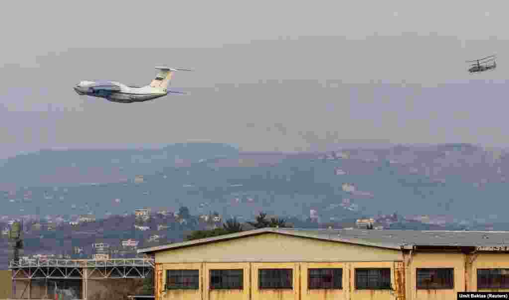 A Russian transporter plane takes off from the Hmeimim base on December 15 as an attack helicopter flies behind.&nbsp; Bektas says the base is busy with aircraft, but around the Russian compound, the streets are &quot;very quiet... You can see trolleys, a wheelchair lying around, lots of stuff spread out on the road. It gives you the feeling that [something happened] when the rebels arrived at the base.&quot;&nbsp; &nbsp;