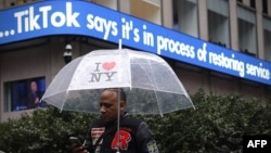 A man walks past an information display in New York City following TikTok's announcement on January 19 that it was restoring its service in the United States. 