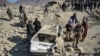 Taliban security personnel inspect a damaged car two days after air strikes by Pakistan in the Barmal district of eastern Paktika Province on December. 