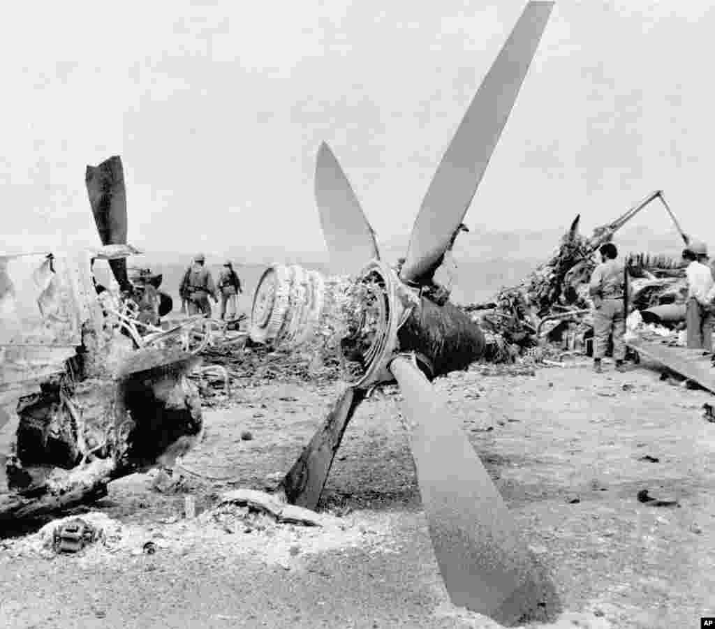 The wreckage of a burned-out American C-130 Hercules cargo plane is inspected by Iranian troops in the Dasht-e Kavir desert, some 500 kilometers from Tehran, on April 26, 1980. An RH-53 helicopter collided with the plane during the attempt to free the American hostages. Mechanical problems and a sandstorm hampered the mission, and a U.S. commander advised Carter to abort. The accident happened after the abort order was given. The helicopter&#39;s rotor churned up sand, blocking visibility. Carter put much of the blame for his loss in the 1980 presidential election on his failure to free the hostages.