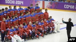 Russian ice-hockey team players pose for a family photo during a training session during the Sochi Winter Olympics February 2014.