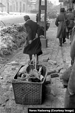 A woman dragging her belongings past Red Army soldiers in central Budapest.