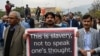 A Pakistan Federal Union of Journalists member holds a banner during a protest against the new amendments to the Prevention of Electronic Crimes Act (PECA) in Islamabad on January 28.