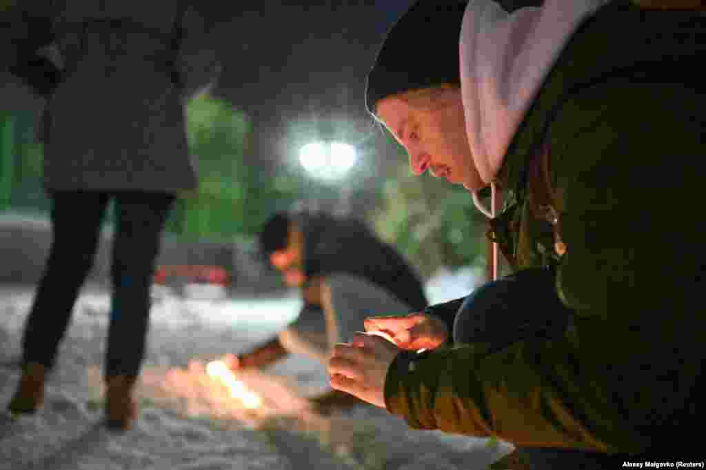 Navalny supporters light candles in a courtyard in Omsk.