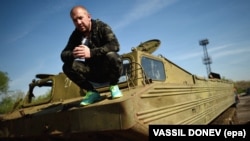 Dinko Valev, who owns a junkyard for trucks and buses, poses on one of his old military vehicles in the town of Yambol, some 240 kilometers from Sofia.