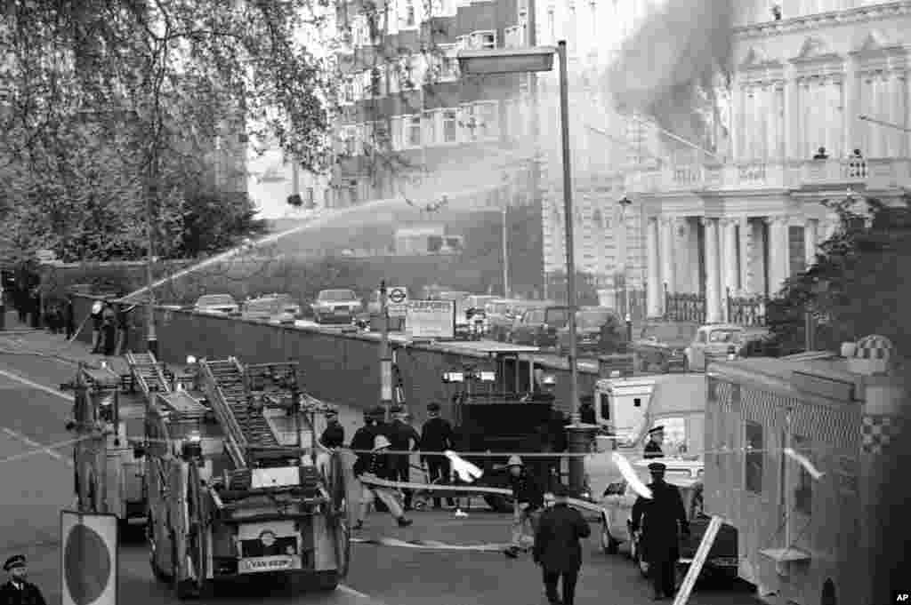 Flames and smoke billow from the embassy after explosions rocked the building. The rescue operation took 11 minutes. Five of the six hostage takers were killed after SAS commandos stormed the embassy.