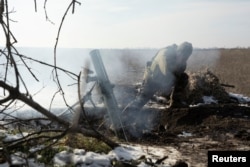 A Ukrainian soldier fires a mortar shell toward Russian troops at a frontline position near Vuhledar on February 11.