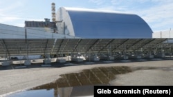 Solar panels in front of the New Safe Confinement arch covering the damaged Reactor No. 4 at Chernobyl. “There is no hope for implementation of the [Enerkon] project," Kateryna Pavlova, a former head of the state agency overseeing the Chernobyl disaster zone, told RFE/RL.