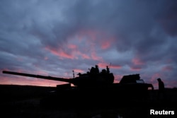 A man walks near a destroyed Russian tank near Izyum on October 31.