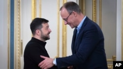 Ukrainian President Volodymyr Zelenskiy (left) and German Christian Democratic Party (CDU) Chairman Friedrich Merz shake hands during their meeting in Kyiv on December 9.