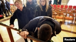 Relatives mourn during a commemoration service for victims of mass New Year's Day shooting in Cetinje, Montenegro, on January 4. 