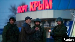 Armed men, believed to be Russian soldiers, stand outside the civilian port in the Crimean town of Kerch on March 3.