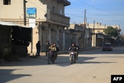 Anti-government fighters patrol a street in the predominantly Kurdish town of Tal Rifaat on December 2, after pro-Turkey factions seized it.