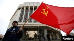 A man holds a Soviet flag as he attends a pro-Russian rally at the Crimean parliament building in Simferopol in March.