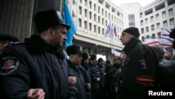 Ukrainian police separate ethnic Russians (right) and Tatars during rallies near the Crimean parliament building in Simferopol.