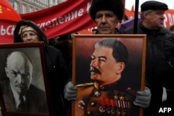 Russian communist supporters carry portraits of Soviet Union founder Vladimir Lenin and Soviet leader Joseph Stalin as they take part in a demonstration marking the 99th anniversary of Russia's Bolshevik Revolution in Moscow on November 7.