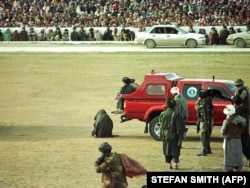 An alleged murderer kneels at the Kabul national stadium moments before his death at the hands of the brother of the victim, in 1998.