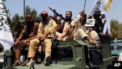 Taliban fighters celebrate the third anniversary of the withdrawal of U.S.-led troops from Afghanistan on August 14. 