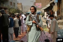 A Taliban fighter stands guard as Muslims offer Friday noon prayers at the Aba Saleh Almahdi Mosque in Kabul on October 1.