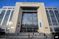 People walk outside the Bucharest Court, where a judge extended the initial detention period of 24 hours for Andrew Tate and his brother Tristan to 30 days on December 30.