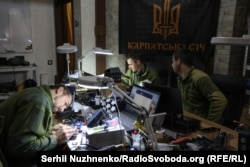 Ukrainian soldiers working on drone components.