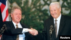 Former U.S. President Bill Clinton (left) and former Russian President Boris Yeltsin shake hands at the close of the Helsinki Summit on March 21, 1997.