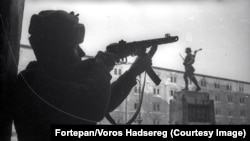 A Soviet soldier photographed near a monument to a Hungarian military unit.