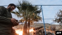 An anti-government fighter remotely fires rockets against regime forces in the northern outskirts of Syrian city of Hama on December 4.