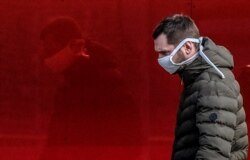 A man wearing a face mask walks along a street in Moscow on March 23. “The number of people who are sick is significantly higher in reality,” said Moscow Mayor Sergei Sobyanin.