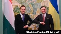 Ukrainian Foreign Minister Dmytro Kuleba (right) greets his Hungarian counterpart, Peter Szijjarto, in Kyiv on June 25. 