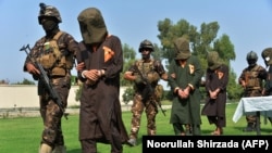 Afghan security personnel escort arrested alleged Islamic State militants during an operation in Jalalabad Province in October 2019.