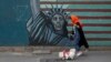 A woman walks her dog past a wall of the former U.S. Embassy in Tehran.