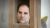 Wall Street Journal reporter Evan Gershkovich stands in a glass cage in a courtroom at the Moscow City Court in December.