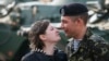 A Ukrainian marine speaks with his wife after a welcoming ceremony in Kyiv after their return from a military base in the Crimean port city of Feodosia.