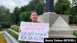 Kazakh civic activist Anna Shukeeva holds a placard reading "Internet freedom -- freedom in Kazakhstan" in Nur-Sultan on July 26.