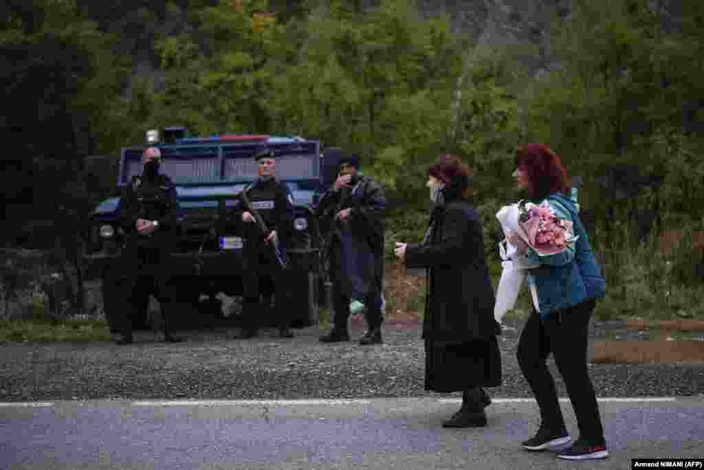 Serbian women walk past Kosovar police after crossing the border on foot in Jarinje on September 28. Serbian President Aleksandar Vucic has warned NATO that Serbia will intervene in Kosovo if Serbs there come under serious threat from the ethnic Albanian majority.