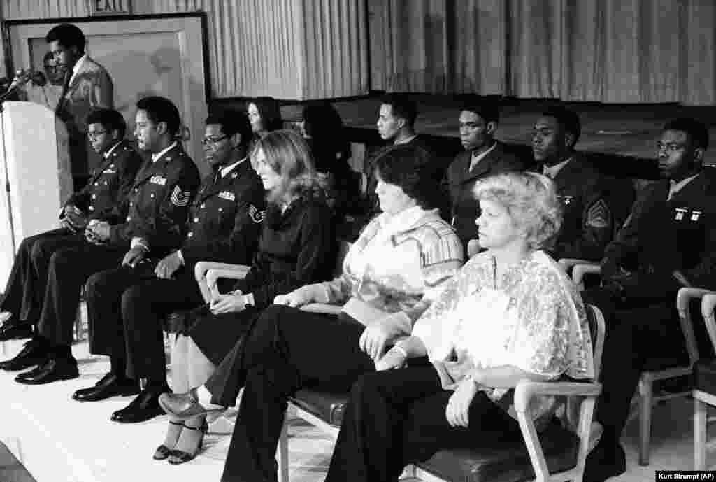 Thirteen Americans were freed on November 21, 1979, and taken to the U.S. Air Force base in Wiesbaden, West Germany, where they appeared before journalists. Lloyd Rollins, at the podium, read a statement from their former captors. Front row from the left: Terry Robinson, Joseph Vincent, James Hughes, Joan Walsh, Kathy Gross, and Anne Johnson. Back row from left: Terry Tedford, Liz Montagne, Wesely Williams, William Quarles, Ladell Maples, and David Walker.