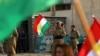 A Peshmerga member affiliated with the Democratic Party of Iranian Kurdistan holds a Kurdish flag ahead of the Kurdistan region's independence referendum in 2017. 