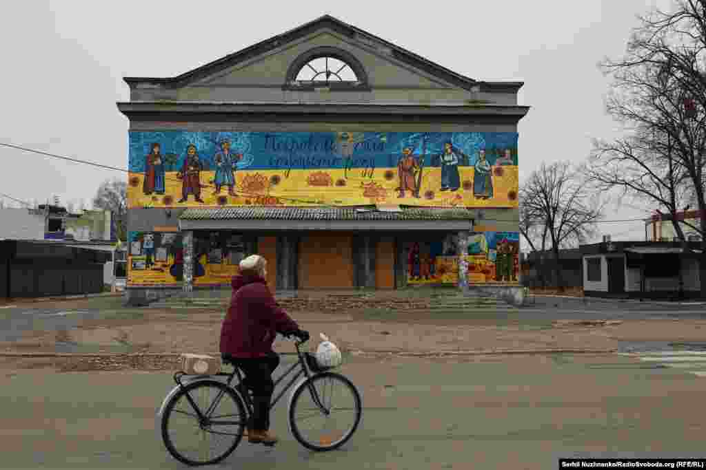 A woman rides past a cinema with a banner declaring &ldquo;Pokrovsk -- the strength of the Cossack clan.&rdquo; A curfew is in place in Pokrovsk from three in the afternoon until 11 a.m. the next day. As soon as the curfew is lifted we park our car and walk through the city streets. Only a handful of people are out and about. In the background, artillery can be heard working to the south and east, where Russian forces are advancing from both directions.