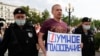 Russian police detain an opposition activist holding a poster featuring the Smart Voting logo during a protest in Moscow last month.