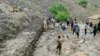 Afghan villagers shovel mud on July 15 following flash floods after heavy rainfall in the Dara district of Panjshir Province. 