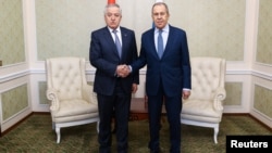 Russia's Foreign Minister Sergei Lavrov (right) shakes hands with Tajikistan's Foreign Minister Sirojiddin Muhriddin as they meet on the sidelines of a CIS conference in Minsk on April 12. 